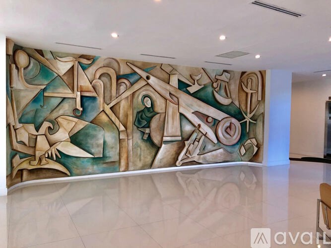 A large abstract painting with various shapes and forms is displayed on a wall.