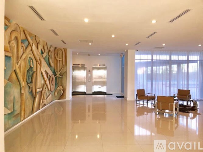 A large room with a mural on the wall and chairs in front of a window.