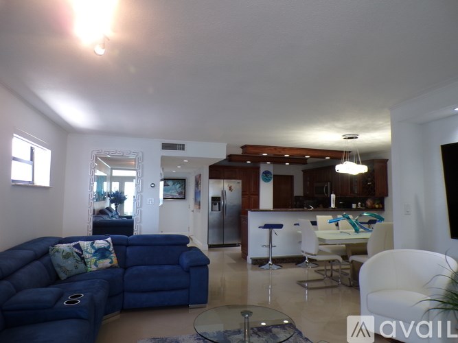 A living room with a blue couch and a white chair.