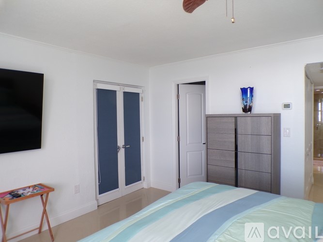 A bedroom with a bed, a television, and a cabinet.