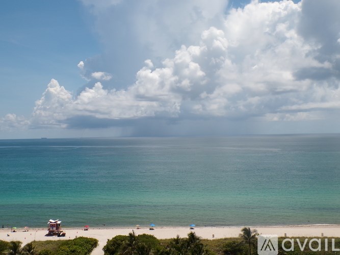 A beach with a blue sky and white clouds.