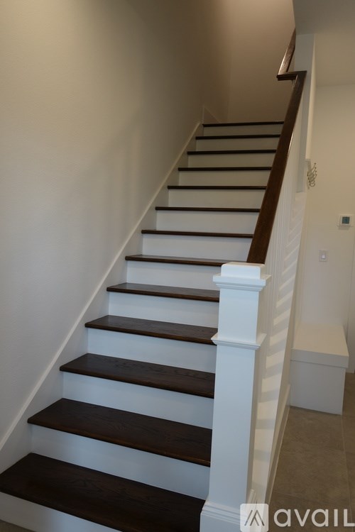 A staircase with white risers and dark wooden treads.