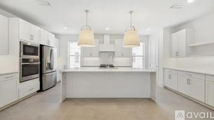 A modern kitchen with white cabinets and appliances.