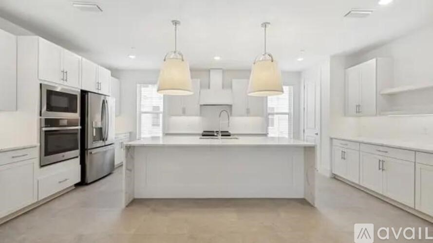 A modern kitchen with white cabinets and appliances.