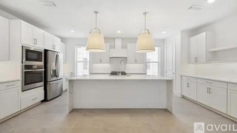 A modern kitchen with white cabinets and appliances.