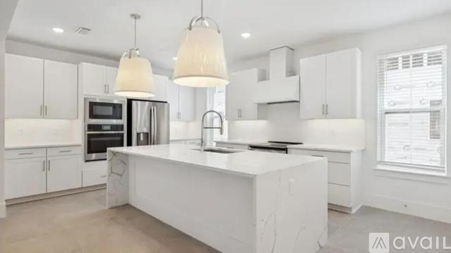 A modern kitchen with white cabinets and a central island.