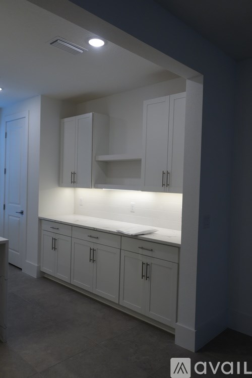 A kitchen with white cabinets and a countertop.