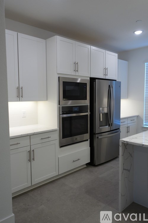 A kitchen with white cabinets and stainless steel appliances.