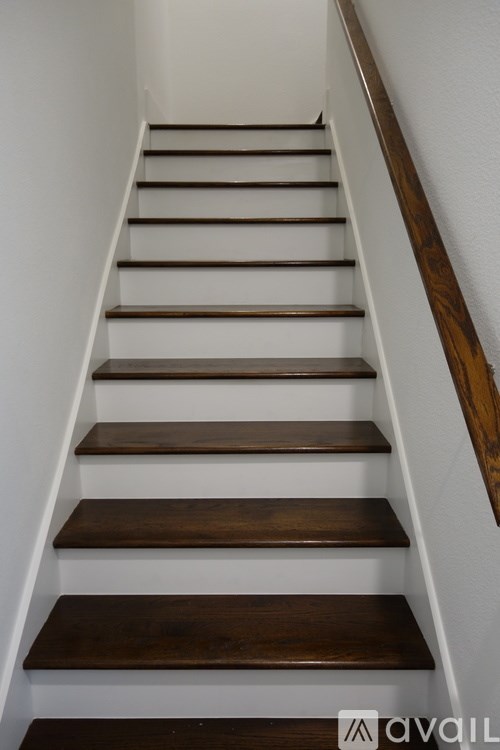 A set of stairs with wooden treads and white risers.