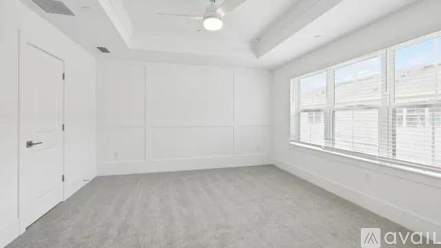 A spacious room with a large window and a door.