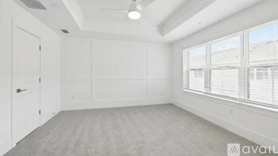 A spacious room with a large window and a door.