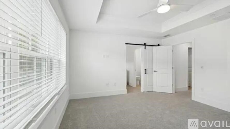 A room with a sliding door and a window with blinds.