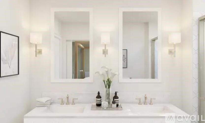 A white bathroom with two sinks and two mirrors.