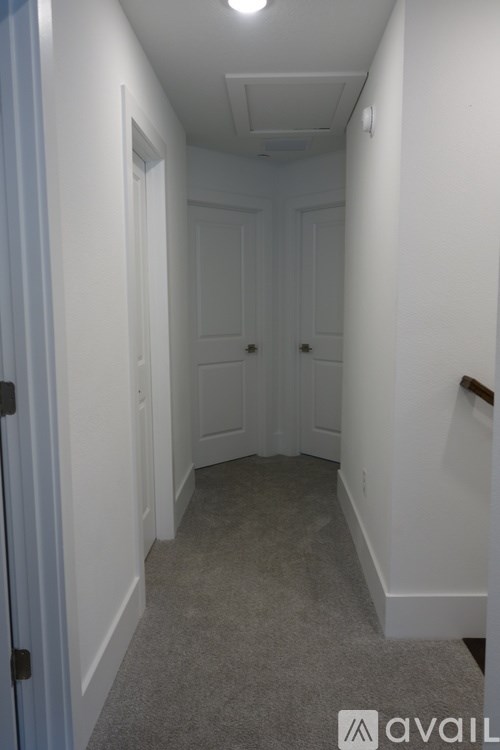 A hallway with white walls and a carpeted floor.