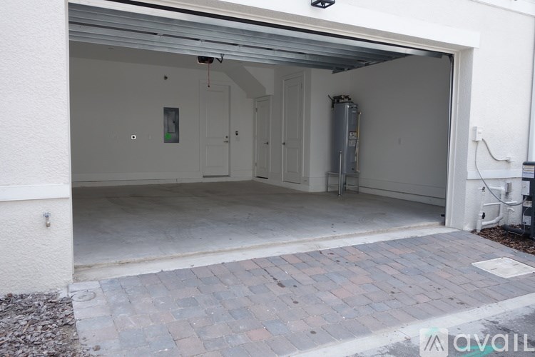 A garage with a brick walkway leading to the door.