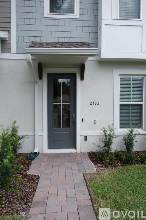 A house with a grey front and a black door.