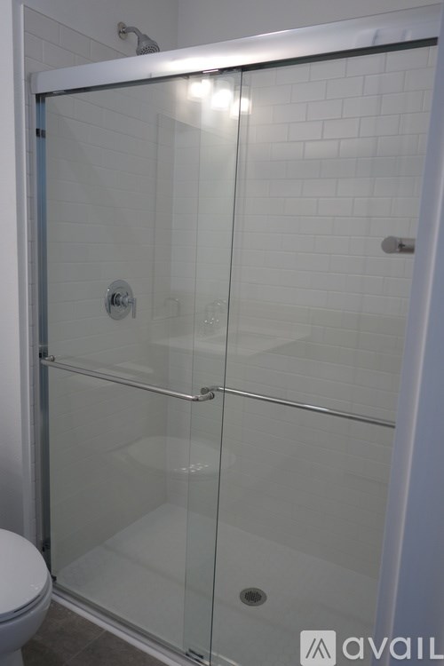 A white toilet is next to a glass shower door.