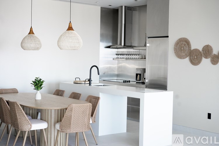 A modern kitchen with a white table and chairs.