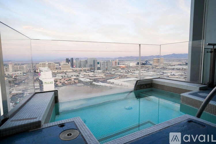 A glass-enclosed pool with a view of the cityscape.