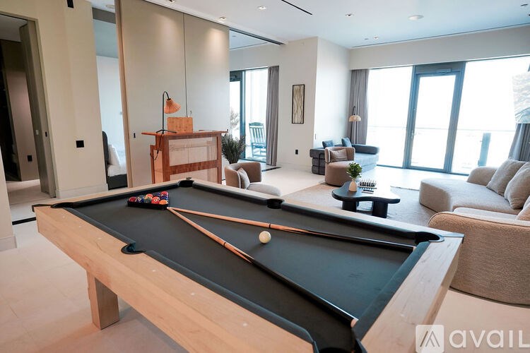 A pool table is in the middle of a living room.