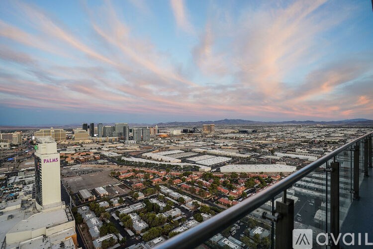 A modern living room with a white sofa and a kitchen area in the background.