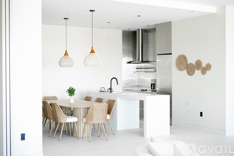 A modern kitchen with a dining table and chairs.