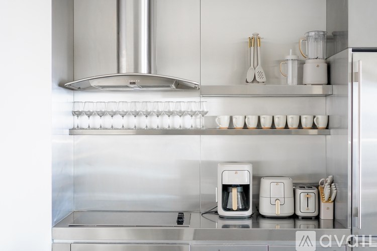 A modern kitchen with a stainless steel finish and white appliances.