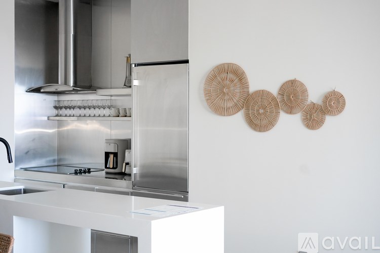 A modern kitchen with a stainless steel range hood and a white countertop.