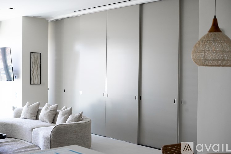 A modern living room with a grey sofa and a hanging lamp.