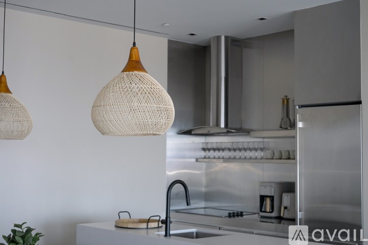 A kitchen with a stainless steel refrigerator and a white countertop.