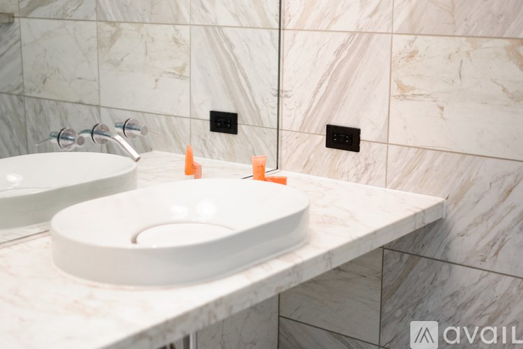 A bathroom with two sinks and a marble wall.