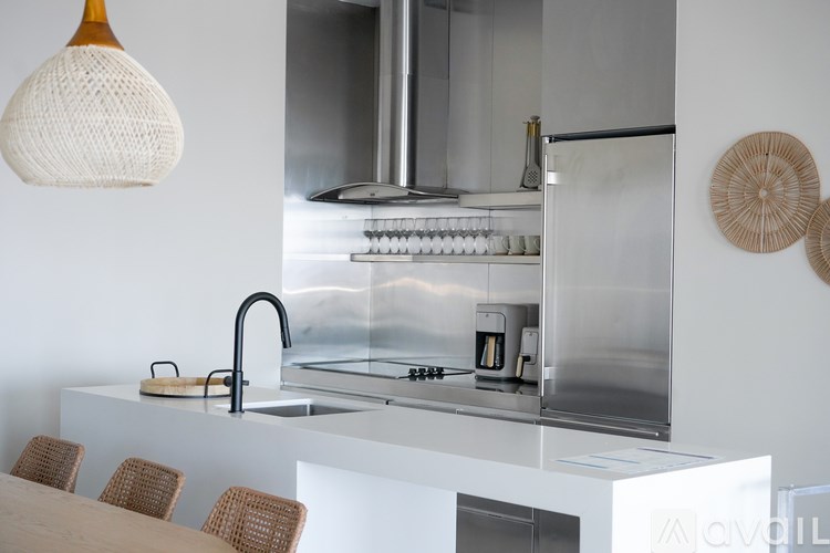 A modern kitchen with a stainless steel refrigerator and a white countertop.