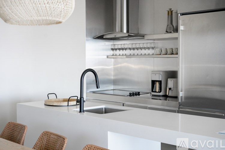 A modern kitchen with a stainless steel refrigerator and a white countertop.