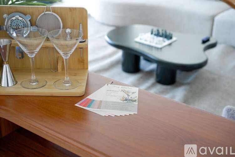 A wooden table with a set of glasses and a card on it.