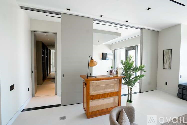 A modern living room with a wooden cabinet and a grey armchair.