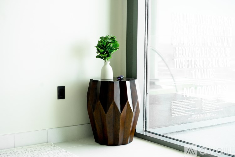 A plant in a brown vase sits on a windowsill.
