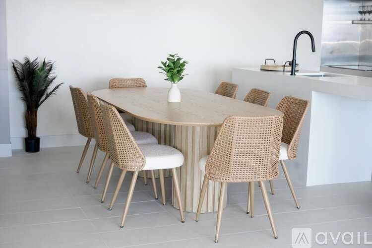 A round dining table surrounded by chairs and a potted plant.