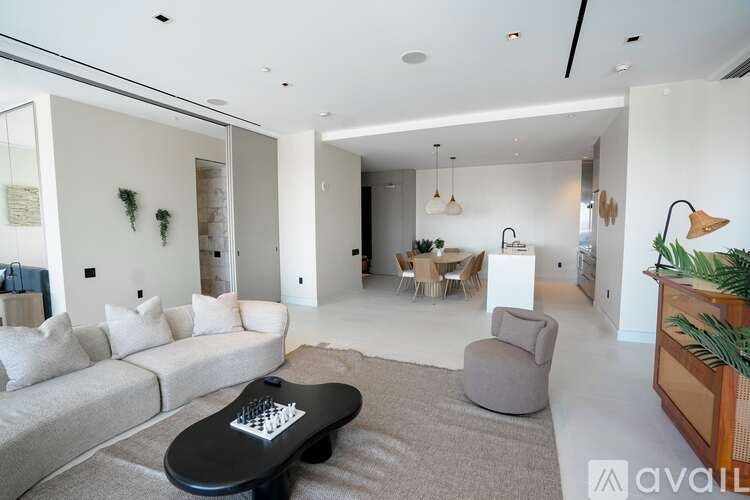 A modern living room with a grey sofa and a black chessboard on the coffee table.