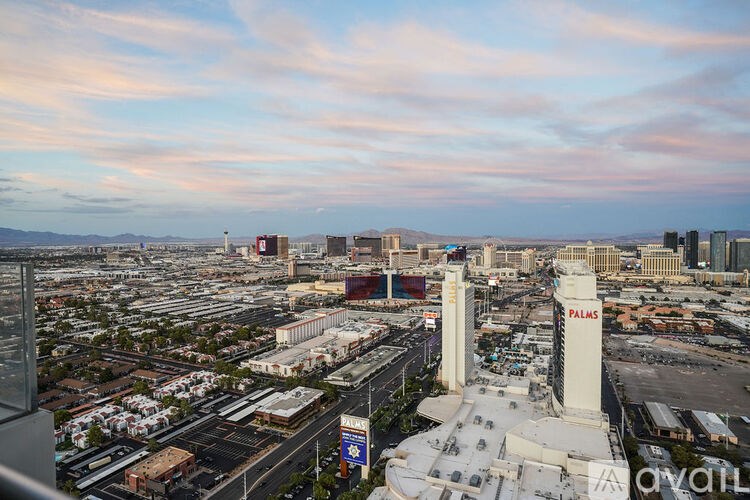 A cityscape with a prominent white building with the word "PALMS" on it.