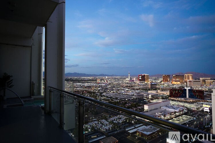 A balcony overlooks a cityscape with buildings and a clear sky.