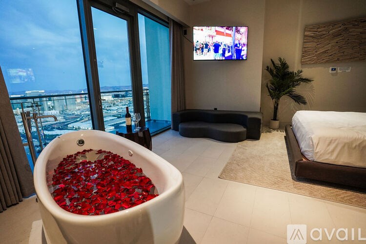 A bathroom with a tub full of red rose petals.