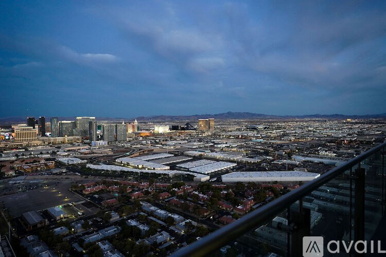 A cityscape with buildings and a cloudy sky.