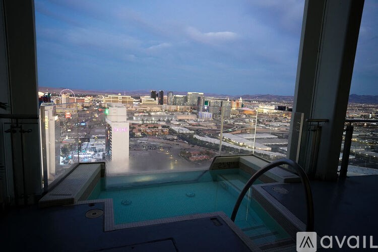 A view from a window overlooking a cityscape with a pool in the foreground.