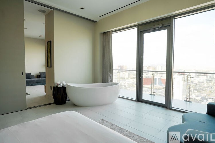 A modern bathroom with a large tub and a view of the city.