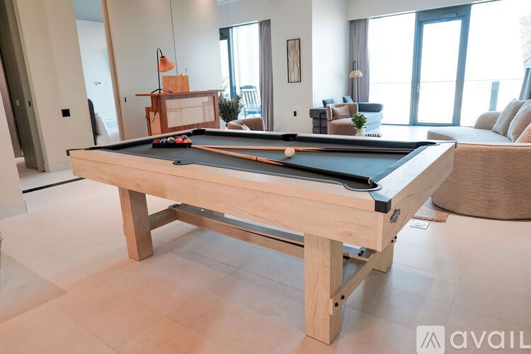A pool table in a room with a couch and a chair.
