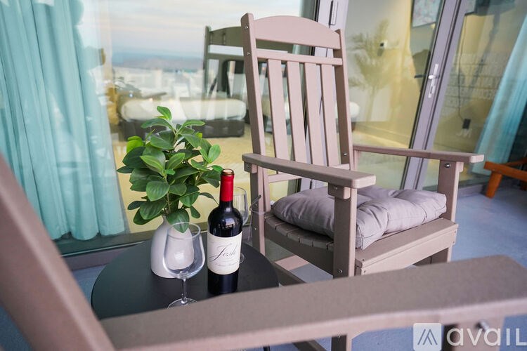 A wooden chair with a pillow and a plant on a table.