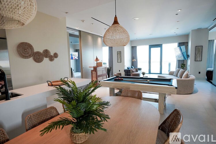 A modern living room with a pool table and a dining table.