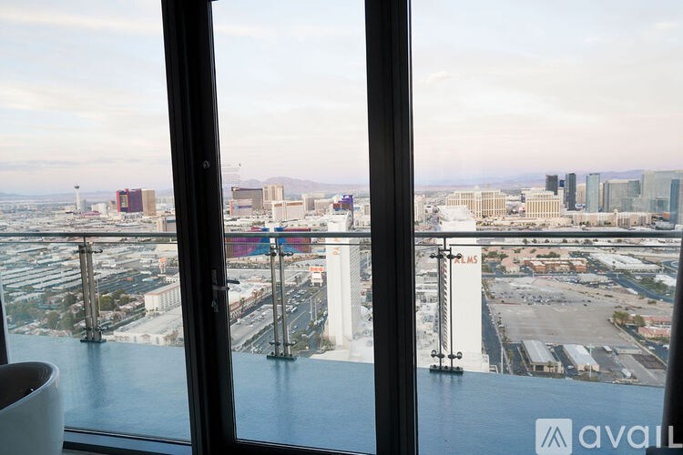A view from a high-rise window looking out at a cityscape.