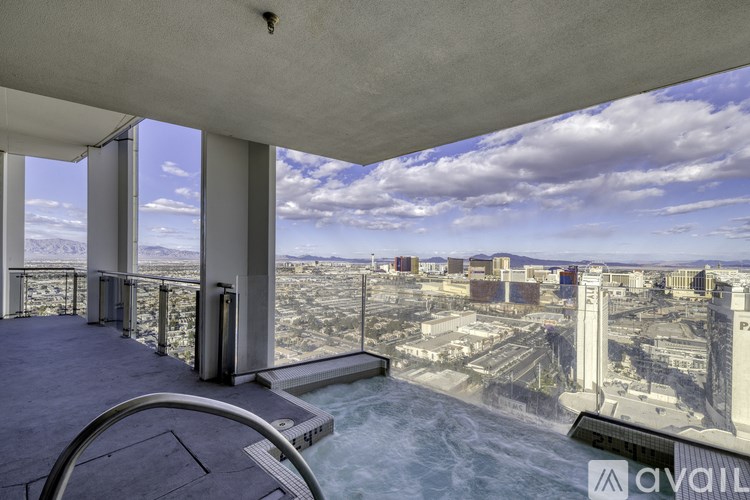 A balcony with a chair and a view of a cityscape.