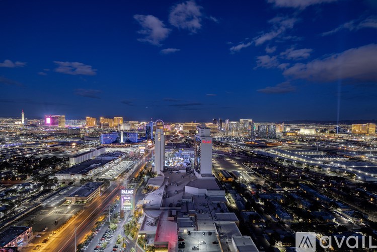 A cityscape at night with a brightly lit building in the center.